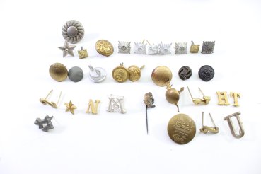 Discover a unique collection of 23 original uniform pieces, buttons, badges, overlays, and buckles