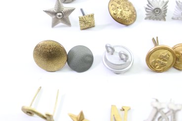 Discover a unique collection of 31 original uniform pieces, buttons, badges, overlays, and buckles