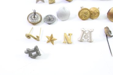 Discover a unique collection of 31 original uniform pieces, buttons, badges, overlays, and buckles