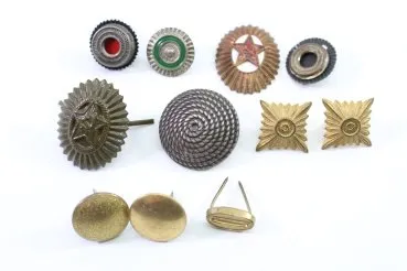 A set of 11 original uniform pieces, buttons, badges, overlays, and buckles