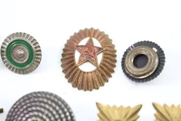 Konvolut aus 11 Stück Original-Uniformteilen, Knöpfen, Abzeichen, Auflagen und Schnallen