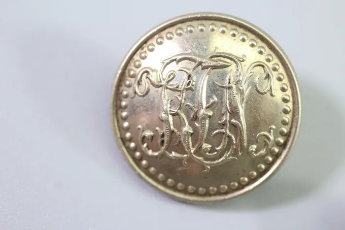 Metal uniform button from the stock of an old uniform tailor,