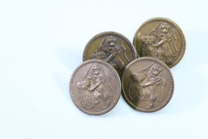 Livery uniform button with lion, crest, and sword, from an old uniform tailor's shop, original piece