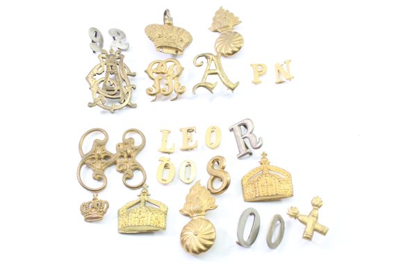 Discover a unique collection of 23 original uniform pieces, buttons, badges, overlays, and buckles