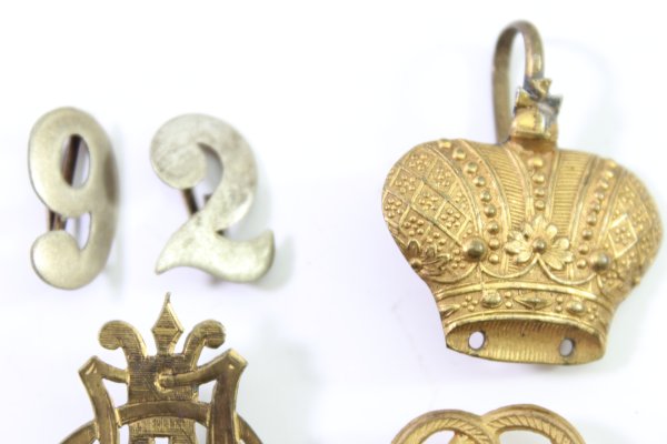 Discover a unique collection of 23 original uniform pieces, buttons, badges, overlays, and buckles