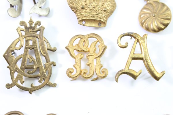 Discover a unique collection of 23 original uniform pieces, buttons, badges, overlays, and buckles