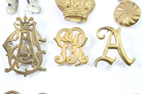 Konvolut aus 23 Stück Original-Uniformteilen, Knöpfen, Abzeichen, Auflagen und Schnallen