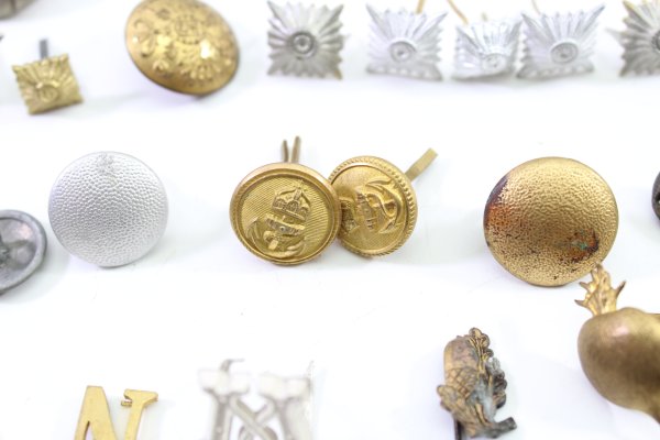 Discover a unique collection of 31 original uniform pieces, buttons, badges, overlays, and buckles