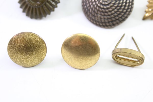 A set of 11 original uniform pieces, buttons, badges, overlays, and buckles