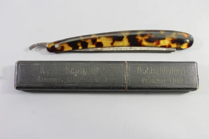 Wehrmacht straight razor with tortoiseshell-effect handles and a matching storage box,