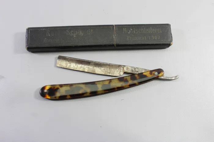 Wehrmacht straight razor with tortoiseshell-effect handles and a matching storage box,