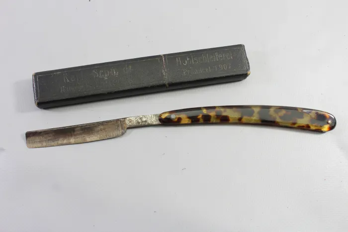 Wehrmacht straight razor with tortoiseshell-effect handles and a matching storage box,