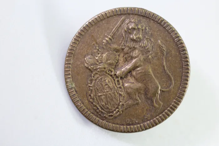 Livery uniform button with lion, crest, and sword, from an old uniform tailor's shop, original piece