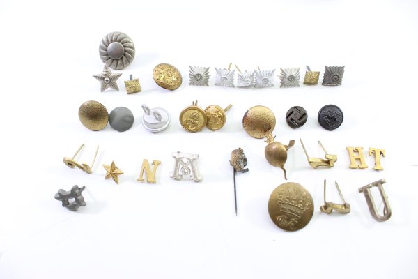 Discover a unique collection of 31 original uniform pieces, buttons, badges, overlays, and buckles