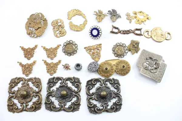 Discover a unique collection of 27 original uniform parts, buttons, badges, overlays, and buckles