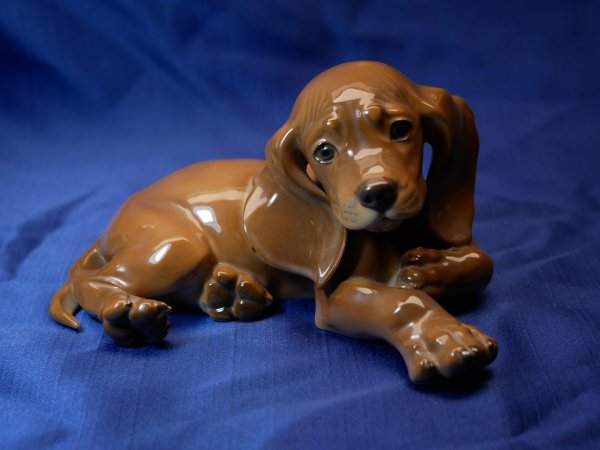 Allach Porcelain Manufactory - young dachshund lying down, colored - design by Prof. Th. Kärner No. 1