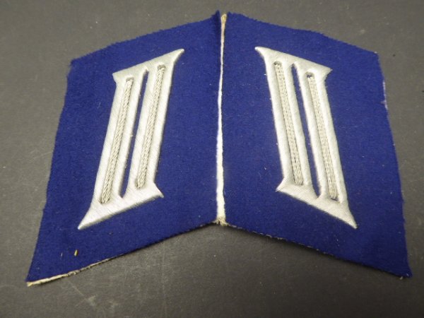 A pair of collar tabs, gun color blue from a tailor's estate