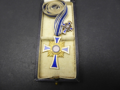 Mother's cross in gold on a ribbon in a case. Manufacturer Walter & Henlein Gablonz + miniature in bronze
