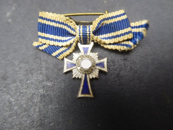 Miniature of the Mother's Cross in silver on a ribbon bow
